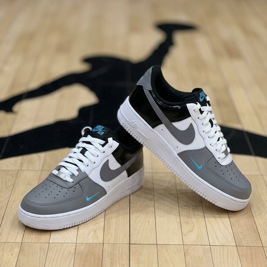 Gray and black sneakers with white soles on a wooden floor